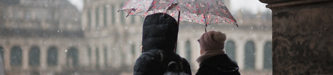 Deux amis se tiennent ensemble sous la pluie.