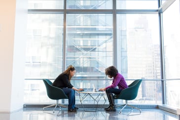 Two people sitting at desk 